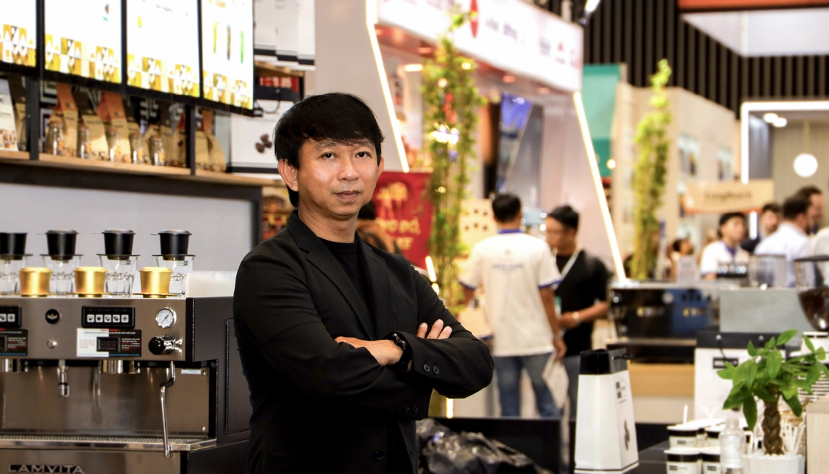 chủ quán E Coffee tự tin trước cửa hàng