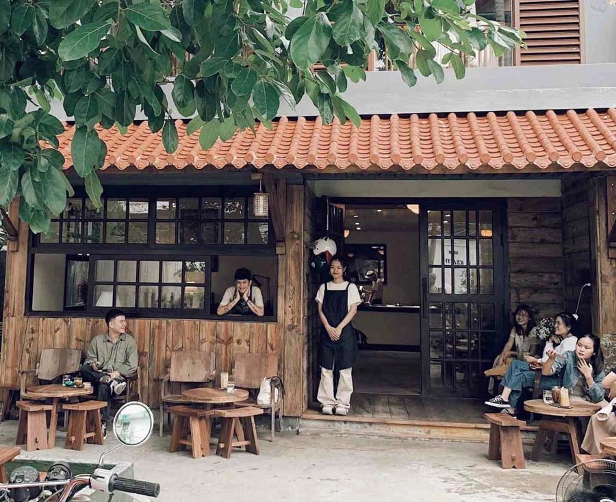 chủ quán tự tin trước cửa hàng Cafe VIP