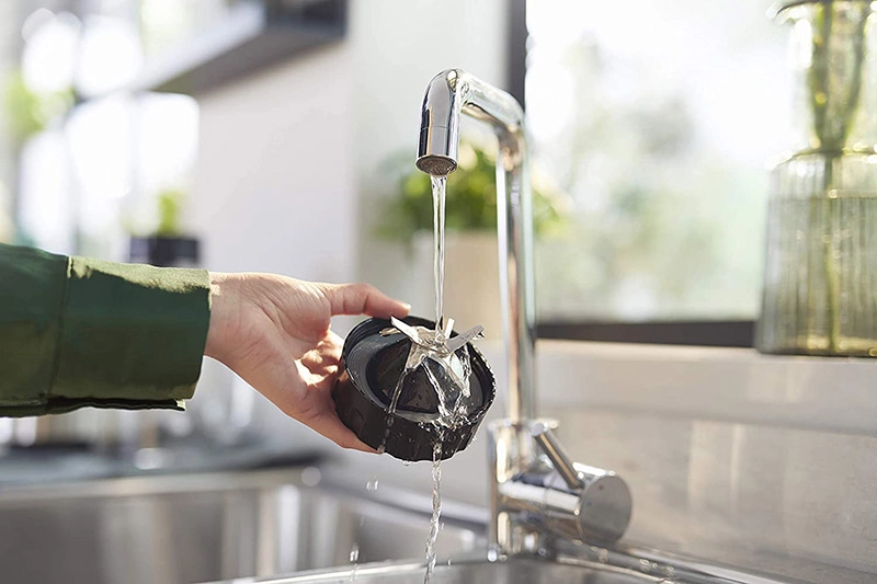 máy xay sinh tố lưỡi dao tháo rời đang rửa dưới vòi