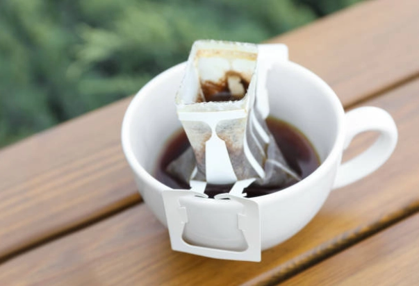Người dùng đọc hướng dẫn pha trên bao bì cà phê túi lọc