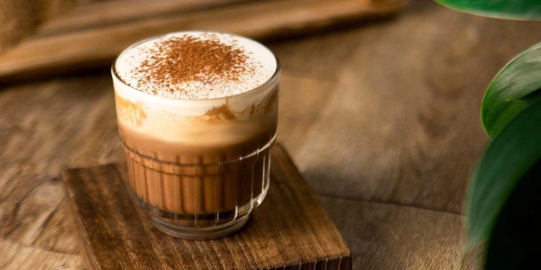 rắc bột cacao lên ly cà phê kem trứng nóng